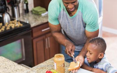 A father helping his son with his meal